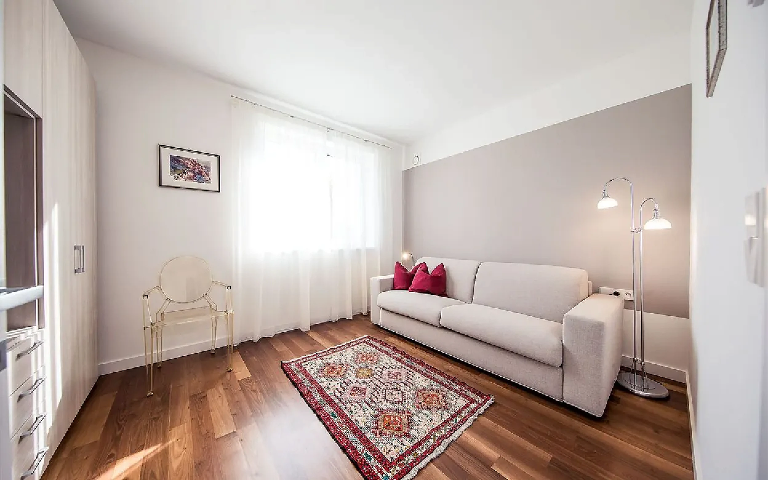 Wohnzimmer mit Schlafcouch und Holzboden